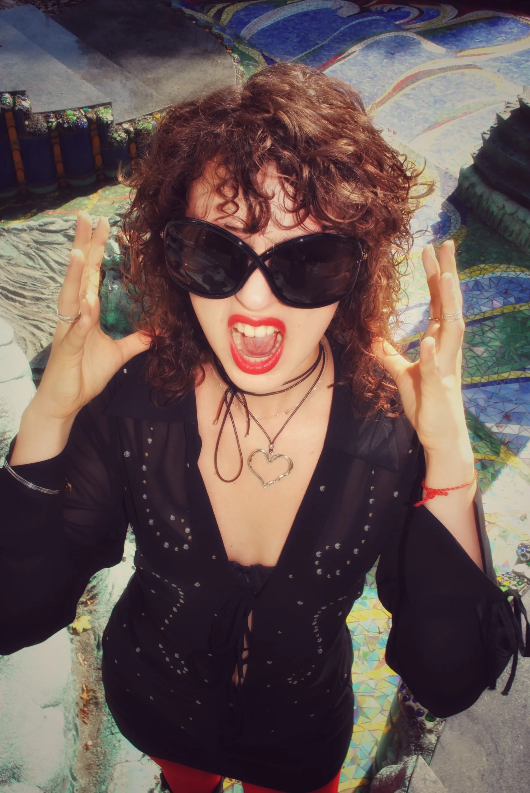 Model in big black sunglasses and red lipstick against a mosaic, Otto Wagner Villa
