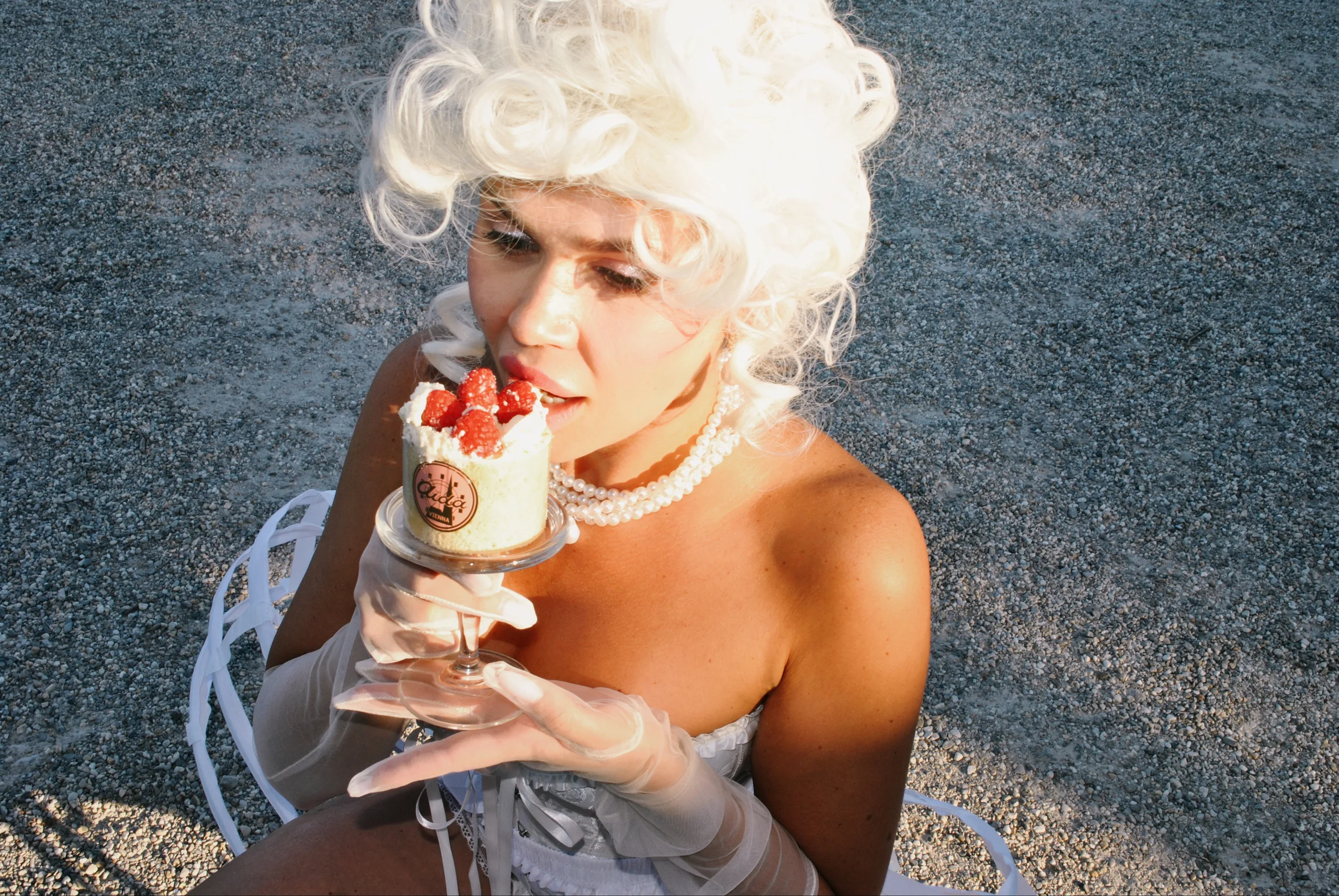 Marie Antoinette with a strawberry cake on a gravel path in Schönbrunn, shot with flash