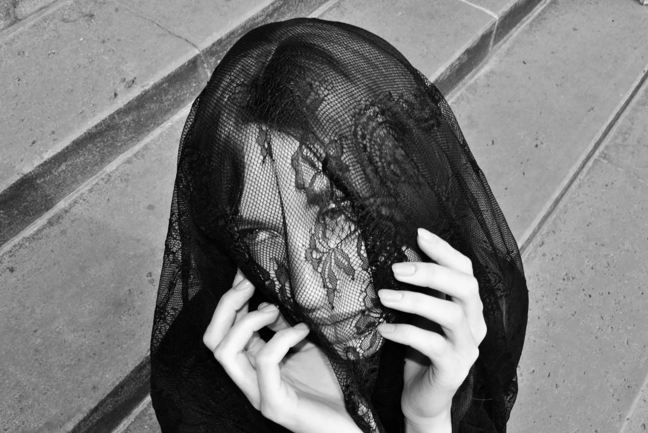 Black and white portrait under a black lace veil